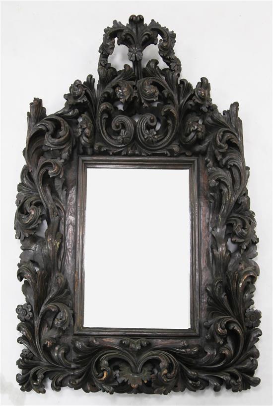 A 17th / 18th century Portuguese baroque carved chestnut wall mirror, 3ft 10in. x 2ft 8in.